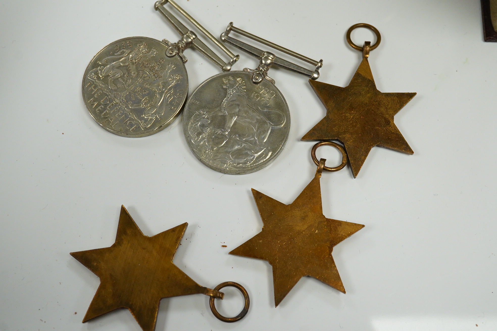 Five WWII medals including the Italy star, the France and Germany star, etc. and a cased miniature of a First World War officer in uniform, plus a leather cylindrical case. Condition - fair to good, significant chip to t